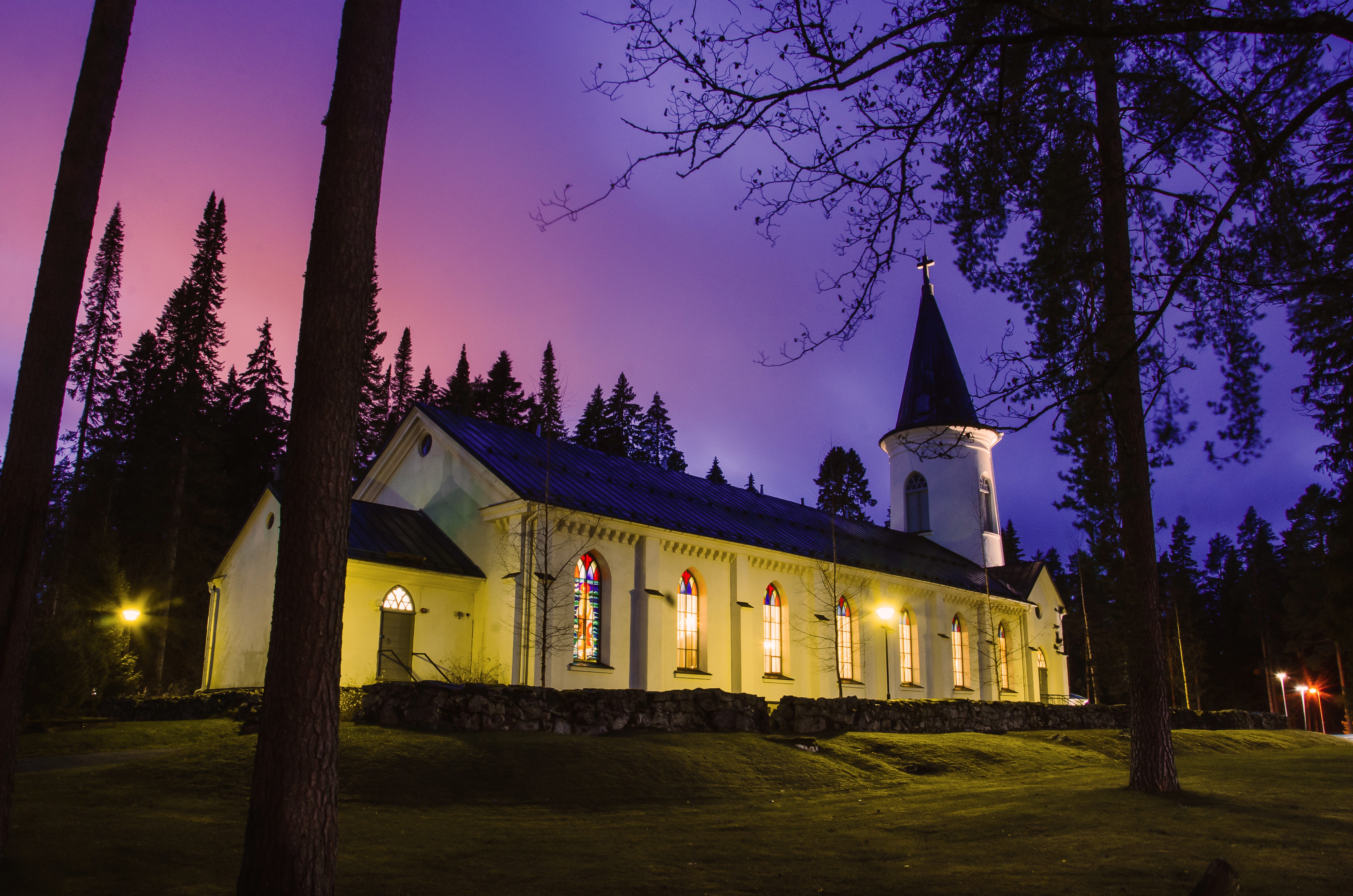 Törnävän kirkko kuvattuna violetin sävyisen maiseman edessä.