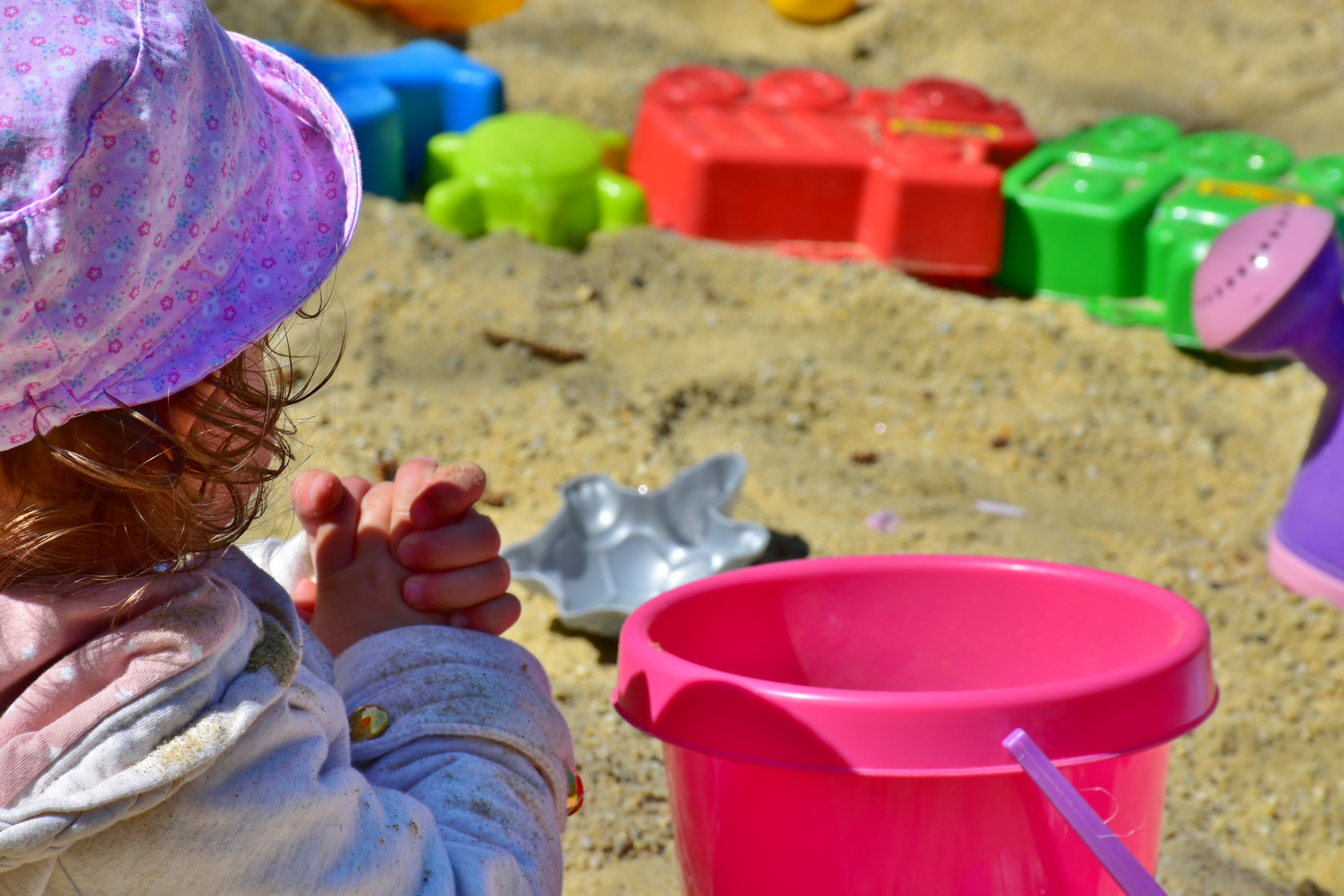 Pieni tyttö hiekkalaatikolla.