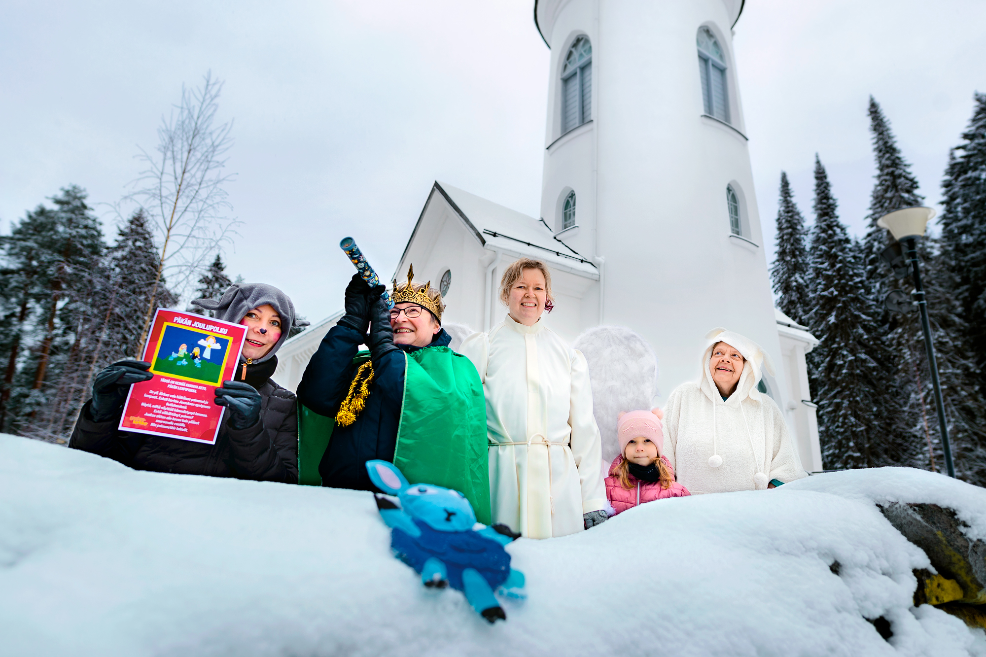 Lumipenkan takana varhaiskasvatuksen työntekijöitä pukeutuneena joulupolun hahmoiksi.