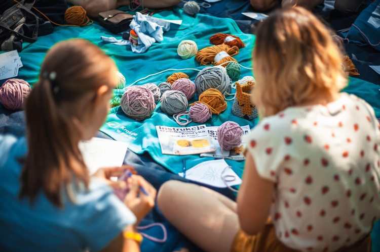 Kudo julkisesti Olotilalla Ihmisiä picnicpeitolla tekemässä käsitöitä