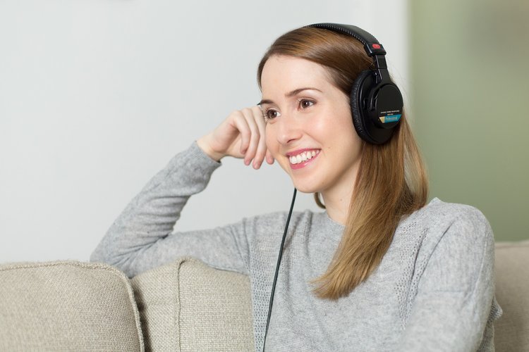 Nuori nainen kuuntelee radiota kuulokkeilla.
