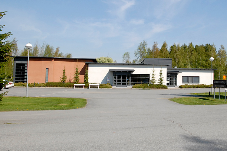 Peräseinäjoen seurakuntatalo Peräseinäjoen seurakuntatalon etupihan parkkipaikka ja ulko-ovi.