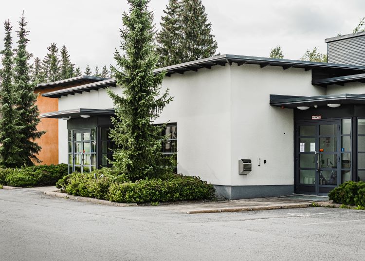 Peräseinäjoen seurakuntatalo Peräseinäjoen seurakuntatalon etupihan parkkipaikka ja ulko-ovi.