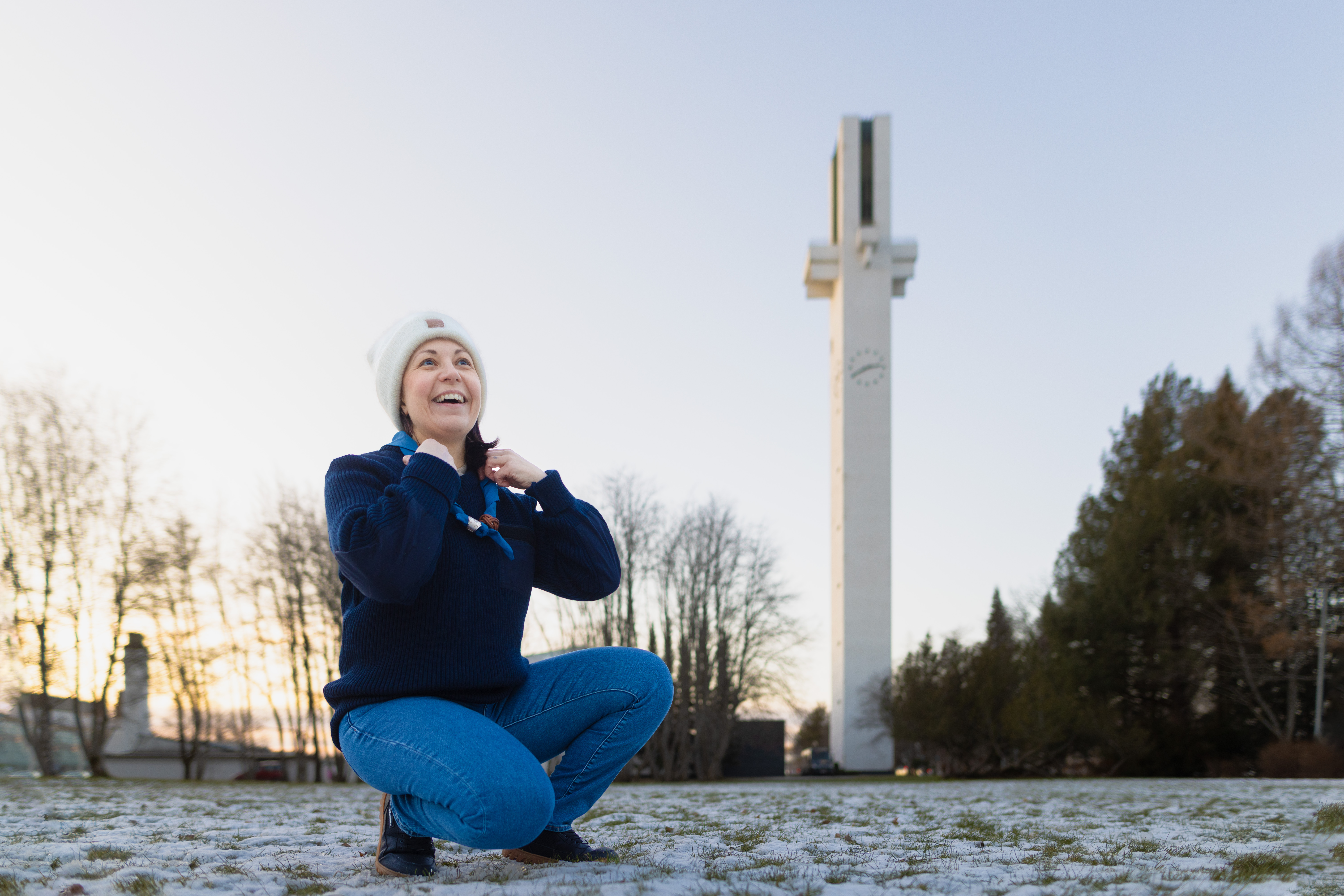 Nainen pitelee kaulassa olevaa partiohuiviaan ja taustalla siintää Lakeuden Ristin torni.